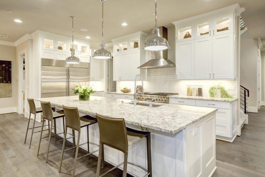 white kitchen illuminated by pendant lighting